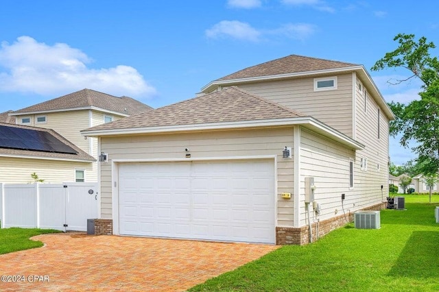 exterior space featuring central AC, a yard, and a garage