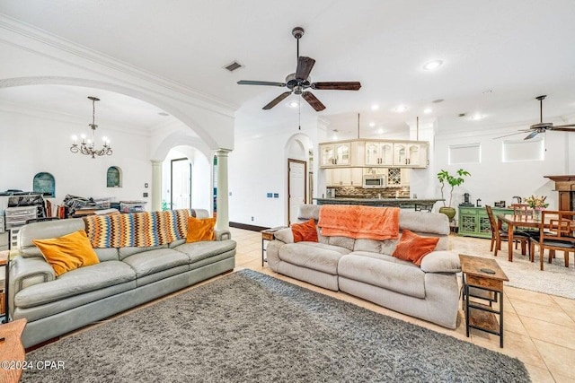 living room featuring ornamental molding, ceiling fan with notable chandelier, and light tile patterned floors