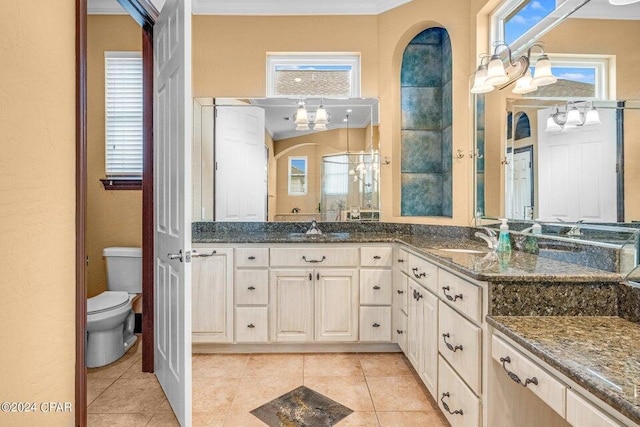 bathroom with toilet, a wealth of natural light, tile patterned flooring, ornamental molding, and vanity