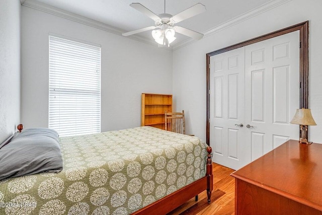 bedroom featuring ceiling fan, hardwood / wood-style floors, ornamental molding, and a closet