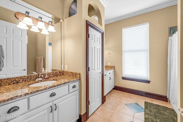 bathroom with plenty of natural light, tile patterned flooring, ornamental molding, and vanity