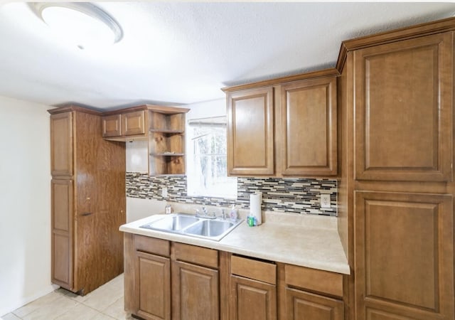 kitchen with light tile patterned flooring, tasteful backsplash, and sink