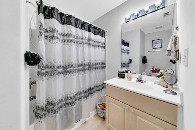 bathroom featuring walk in shower, tile patterned flooring, and vanity