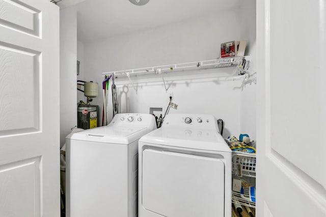 laundry room with electric water heater and separate washer and dryer