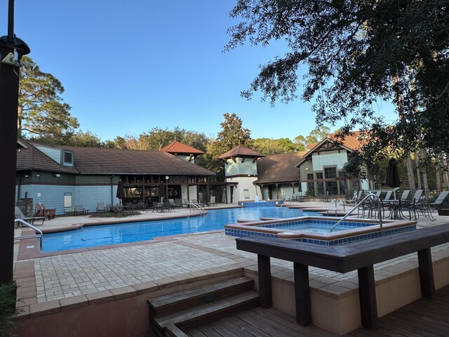 view of swimming pool with a community hot tub and a patio