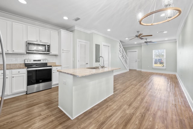 kitchen featuring appliances with stainless steel finishes, ceiling fan with notable chandelier, white cabinetry, and sink