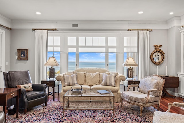 living room with a water view, ornamental molding, and wood-type flooring