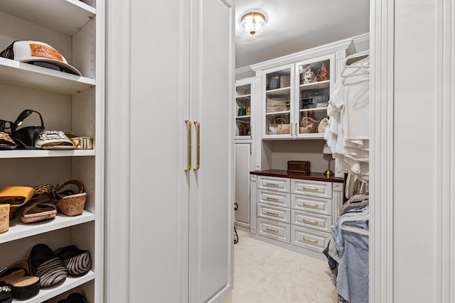 walk in closet featuring light colored carpet