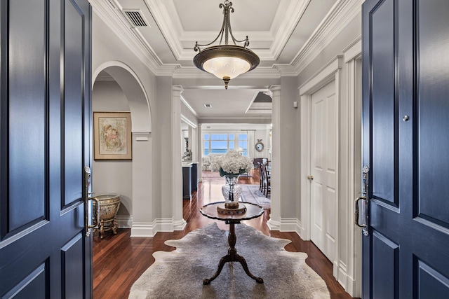 foyer featuring dark hardwood / wood-style flooring, crown molding, decorative columns, and a tray ceiling