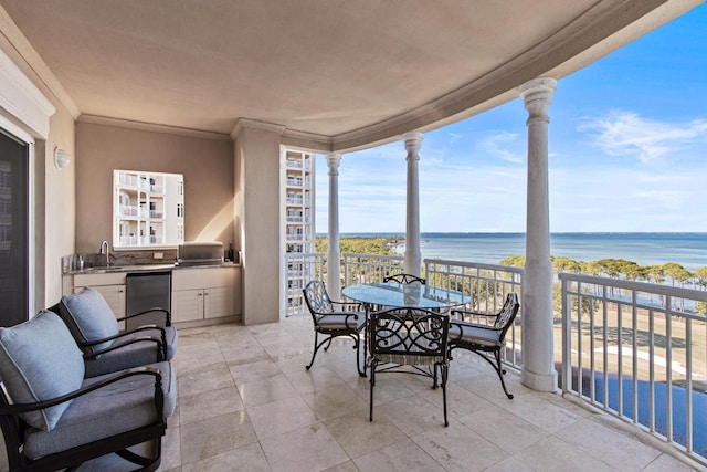 sunroom / solarium featuring a water view, a healthy amount of sunlight, and wet bar