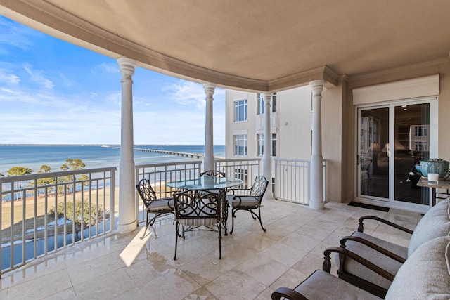 view of patio featuring a water view, a balcony, and a beach view