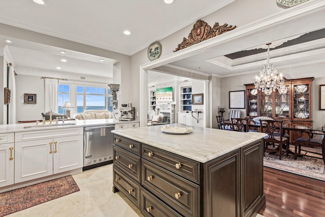 kitchen with dark brown cabinetry, sink, stainless steel dishwasher, ornamental molding, and white cabinets