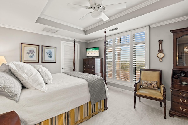 carpeted bedroom featuring ornamental molding, ceiling fan, and a tray ceiling