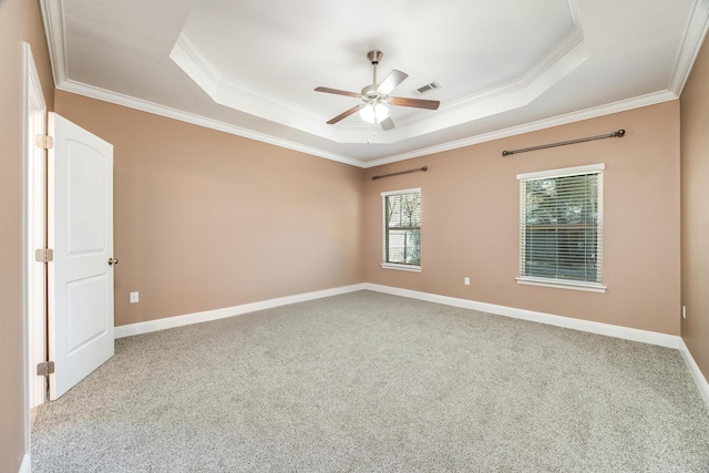 spare room featuring baseboards, carpet floors, ceiling fan, ornamental molding, and a raised ceiling