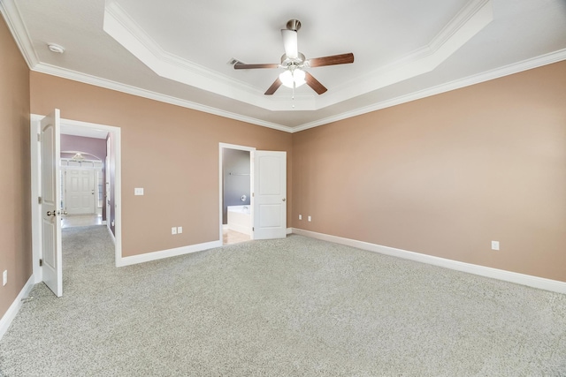 unfurnished bedroom featuring a tray ceiling, crown molding, baseboards, and light carpet