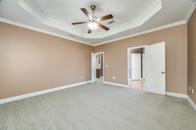 unfurnished bedroom featuring a tray ceiling, baseboards, visible vents, and light carpet