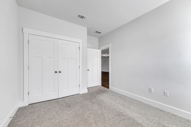 unfurnished bedroom with a closet and carpet floors