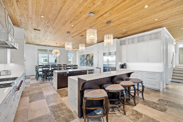 kitchen featuring decorative light fixtures, a center island, stainless steel appliances, and wooden ceiling