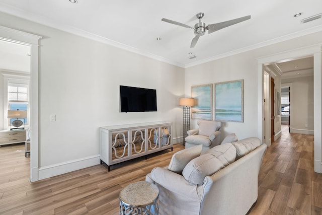 living room with hardwood / wood-style floors, a wealth of natural light, ornamental molding, and ceiling fan