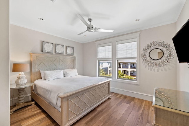 bedroom featuring wood-type flooring, ceiling fan, and ornamental molding