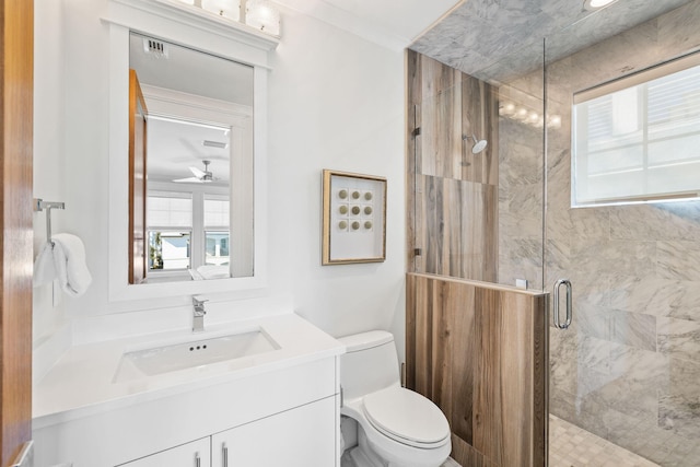 bathroom with a wealth of natural light, vanity, a shower with shower door, and toilet