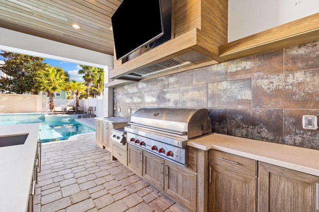 view of patio / terrace featuring a fenced in pool and area for grilling