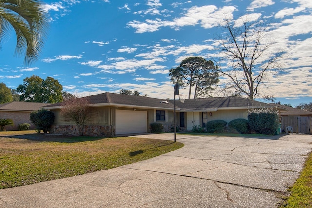 ranch-style house with stone siding, an attached garage, driveway, and a front lawn