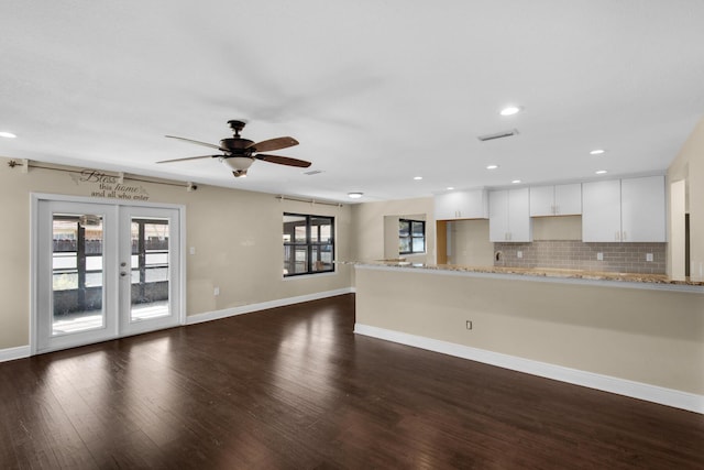 unfurnished living room with ceiling fan, recessed lighting, dark wood-type flooring, baseboards, and french doors