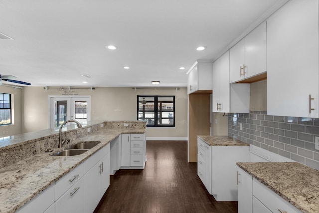 kitchen with dark wood-style flooring, white cabinets, a sink, and decorative backsplash