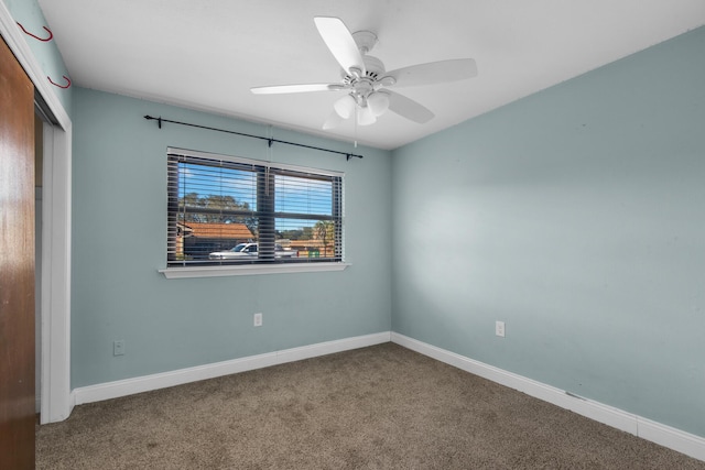 unfurnished room with carpet floors, baseboards, and a ceiling fan