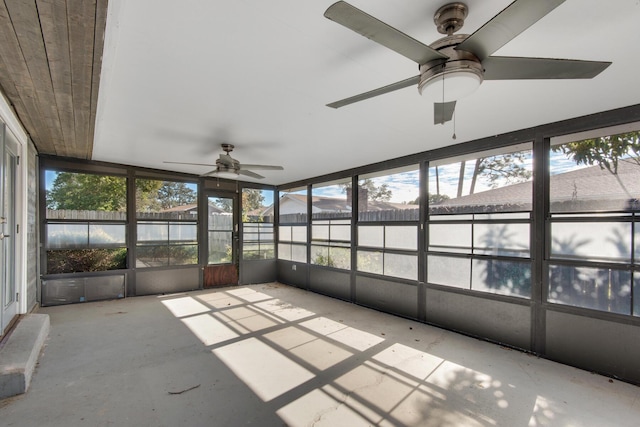 unfurnished sunroom with ceiling fan