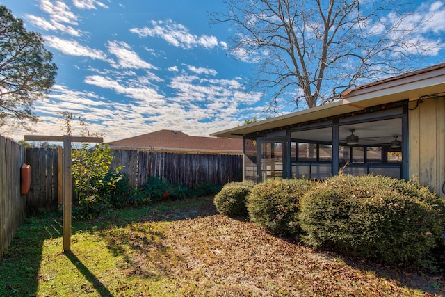 view of yard featuring a sunroom and a fenced backyard