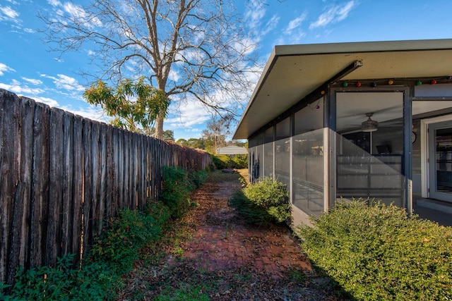 view of side of home featuring fence