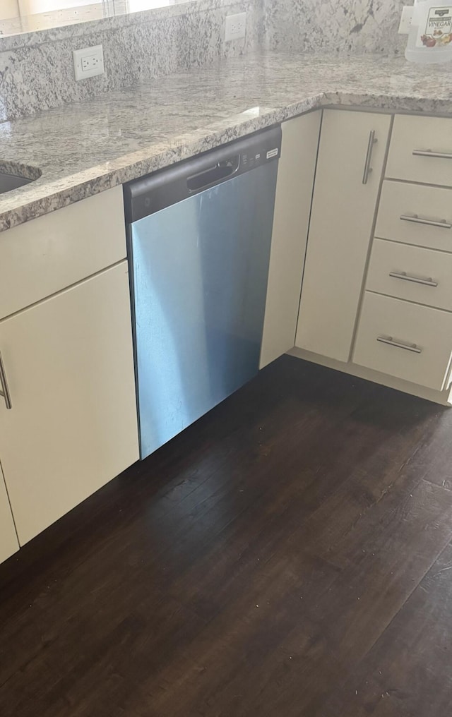 kitchen featuring light stone counters, dark wood finished floors, white cabinetry, and dishwasher