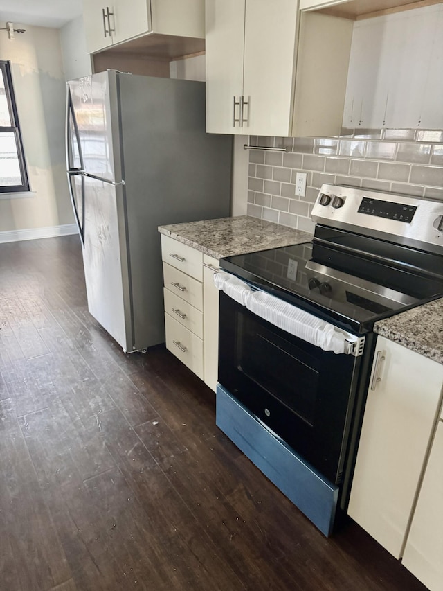 kitchen with light stone counters, decorative backsplash, stainless steel appliances, and dark wood-style flooring