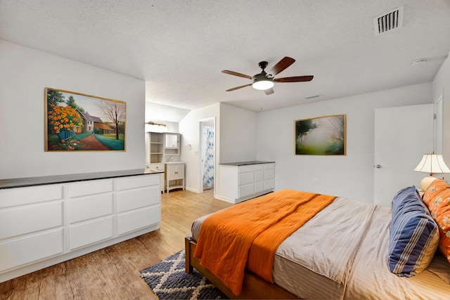 bedroom featuring a textured ceiling, light hardwood / wood-style floors, and ceiling fan