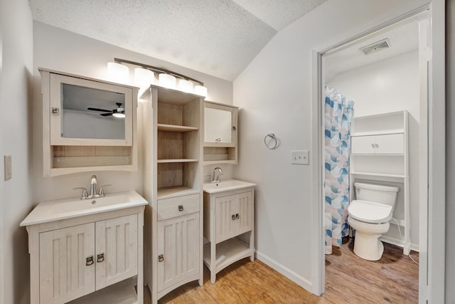 bathroom featuring a textured ceiling, vaulted ceiling, ceiling fan, hardwood / wood-style flooring, and toilet