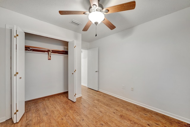 unfurnished bedroom with ceiling fan, a closet, and light hardwood / wood-style floors