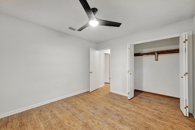 unfurnished bedroom featuring ceiling fan, light hardwood / wood-style floors, and a closet