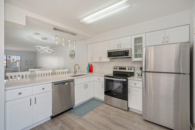 kitchen featuring white cabinets, decorative backsplash, stainless steel appliances, and sink