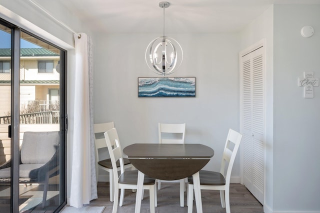 dining area with hardwood / wood-style flooring and an inviting chandelier