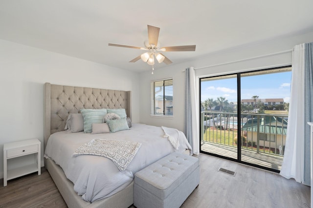 bedroom with access to exterior, hardwood / wood-style floors, and ceiling fan