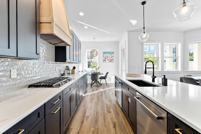 kitchen featuring sink, light stone countertops, hanging light fixtures, and appliances with stainless steel finishes