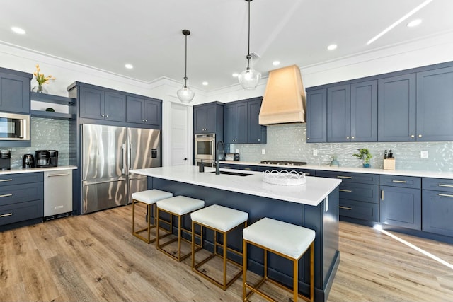 kitchen with a breakfast bar area, stainless steel appliances, light hardwood / wood-style floors, a center island with sink, and custom exhaust hood