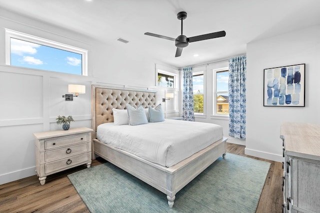 bedroom with hardwood / wood-style flooring, ceiling fan, and multiple windows