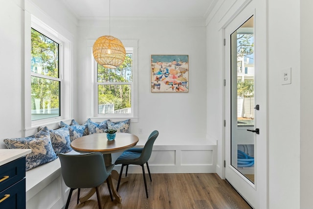 dining space featuring breakfast area, crown molding, and dark wood-type flooring