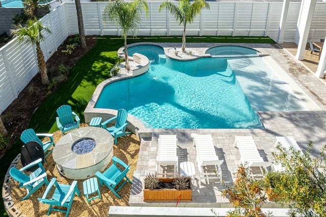 view of swimming pool featuring an outdoor fire pit and a patio