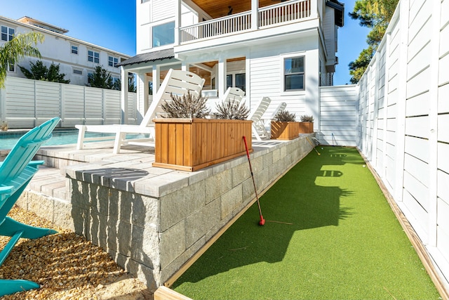 view of patio / terrace featuring a balcony and a swimming pool