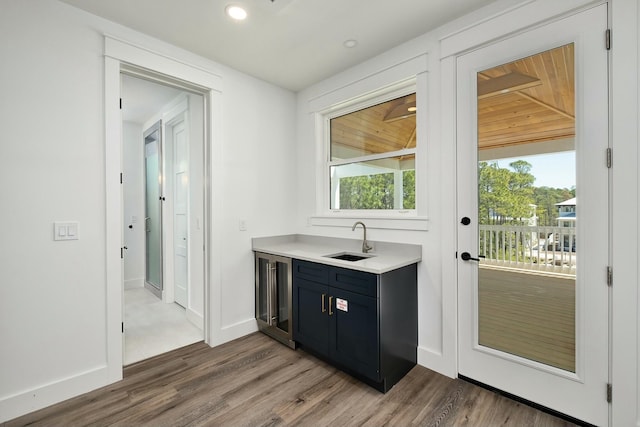 bar featuring wine cooler, sink, and hardwood / wood-style floors