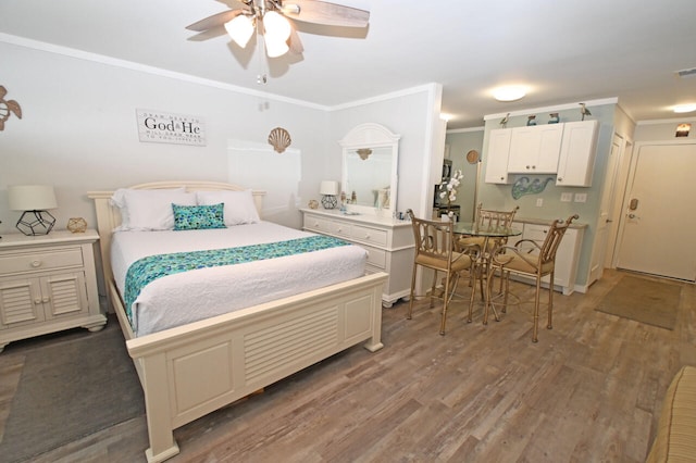 bedroom with hardwood / wood-style floors, ceiling fan, and ornamental molding